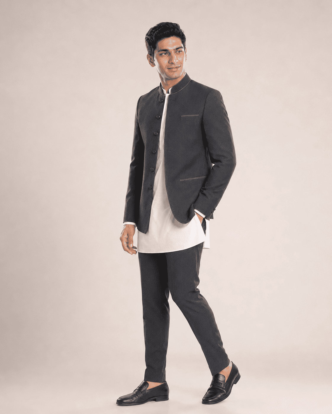 Arjun wearing a black bandhgala over a white kurta, side view